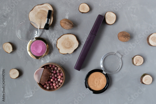  Makeup set on a gray background among the round wood