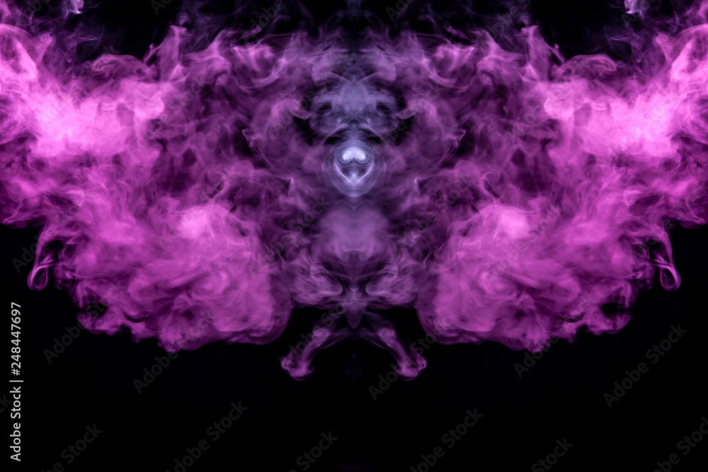 Abstract mystical bat silhouette straightened wings from streams of colorful smoke evaporating from a vape illuminated by neon lights on a black background. Abstract mystical bat silhouette straightened wings from streams of colorful smoke evaporating from a vape illuminated by neon lights on a black background.
