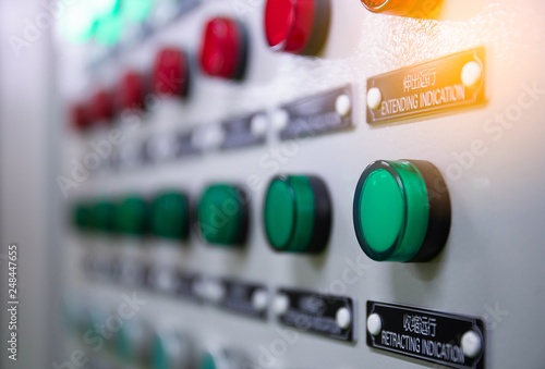 Close up indicator lights fuses on electric cabinet control in factory. The push buttons and dust on control panel 