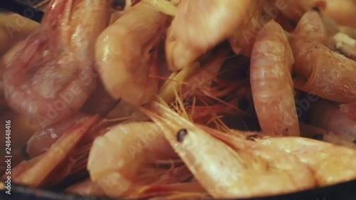 Big shrimps fry on a frying pan.