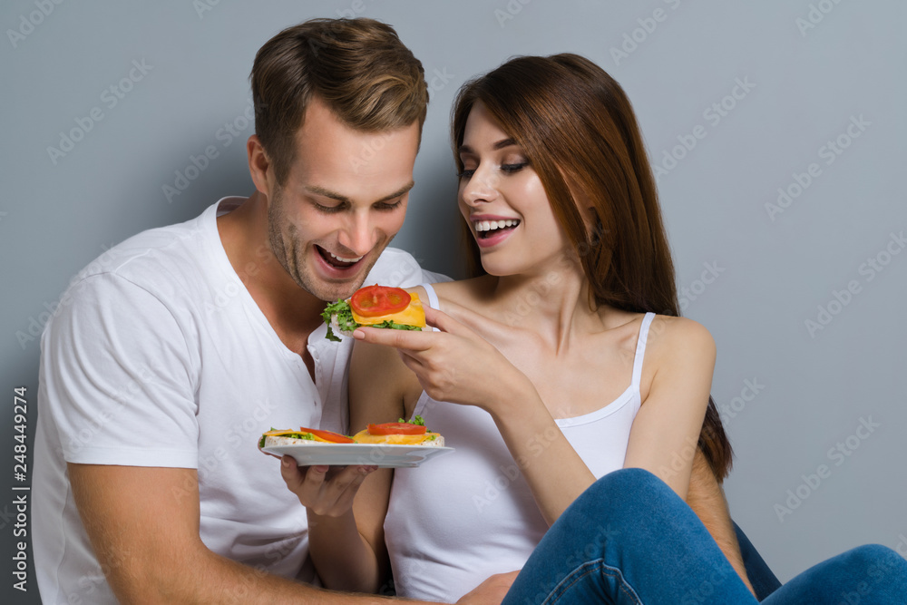 Couple eating crispbread with cheese and tomato Couple eating crispbread with cheese and tomato