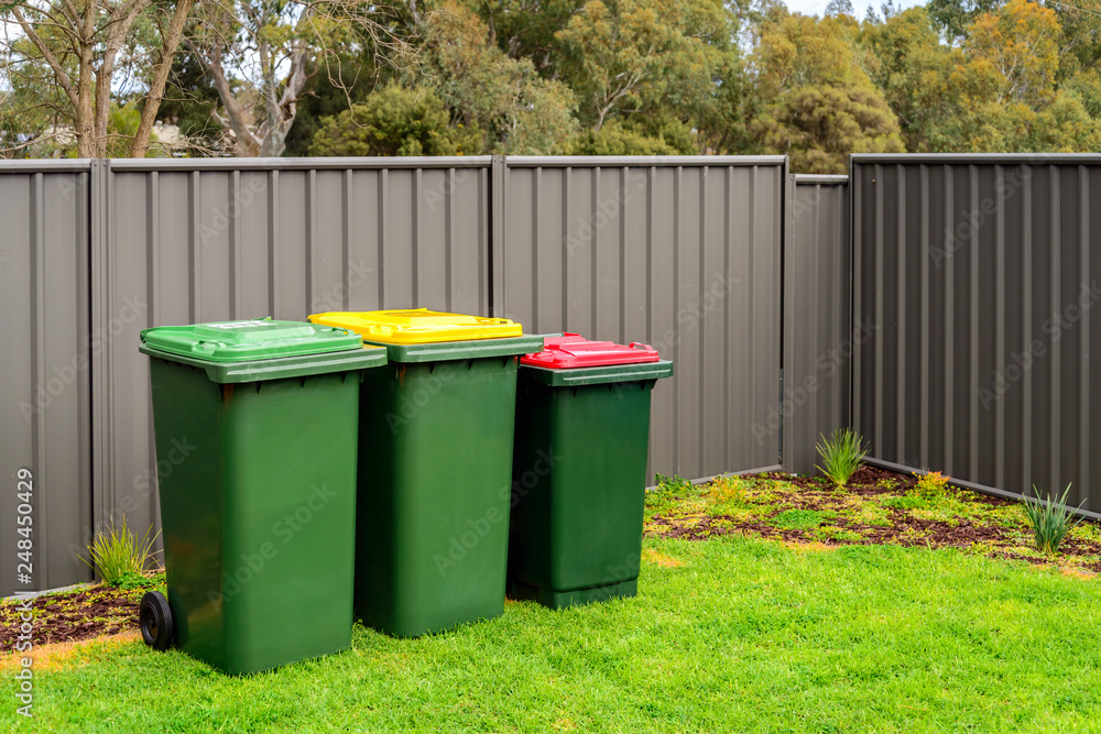 Australian home rubbish wheelie bins set on back yard Australian home rubbish wheelie bins set on back yard