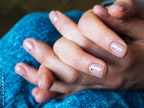 Women's hands are locked in the lock. Nude manicure