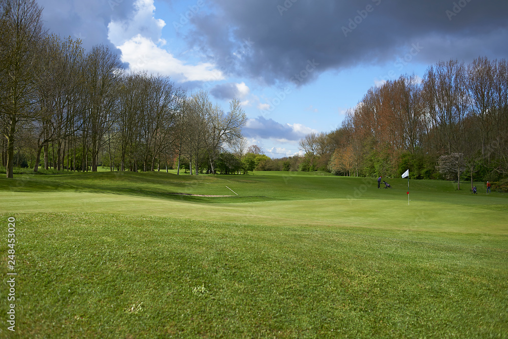 Landscape of a beautiful golf course with greens and holes and bunkers