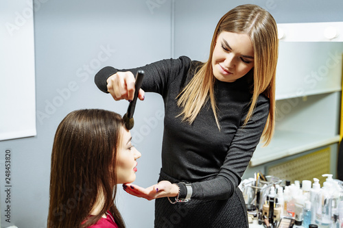 Makeup artist creating beautiful makeup for brunette model . Beauty concept.