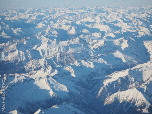 Aerial landscape of the Alps in Europe during winter season with fresh snow. View from the window of the airplane