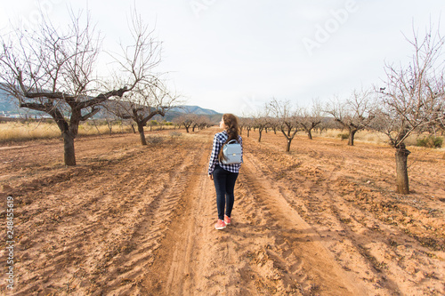 Travel, summer and people concept - woman with stylish backpack on nature background. She is on holiday
