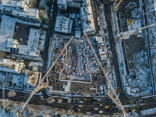 Aerial view of construction site in winter time. Snow covered roofs.