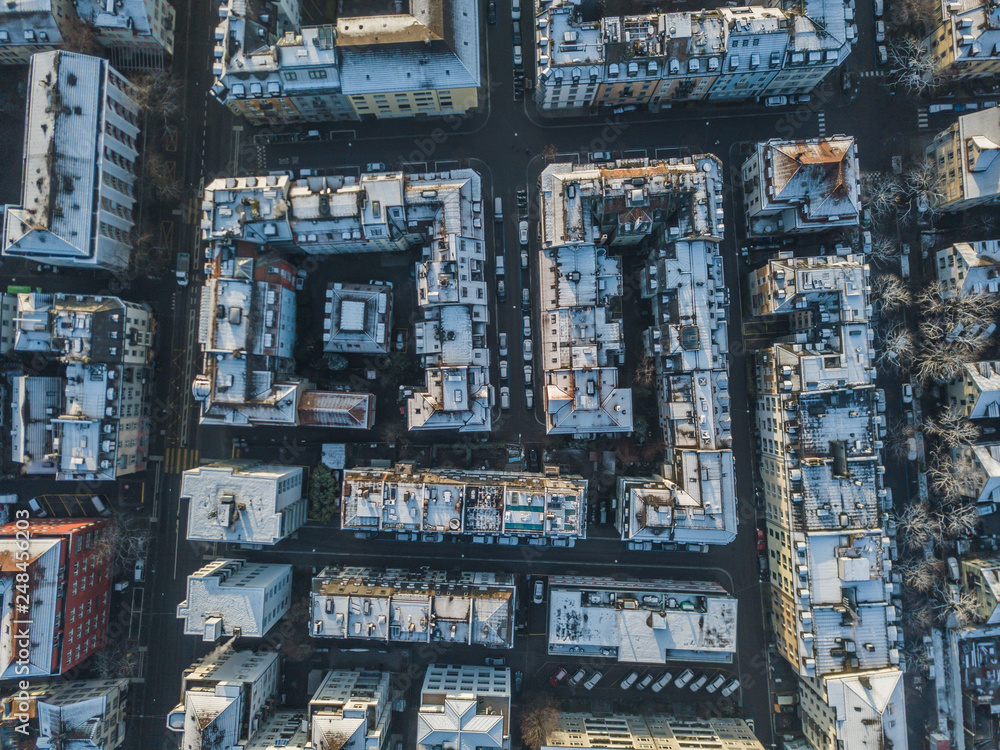 Aerial view of urban block buildings in top view. Pattern of architecture with roofs and streets.