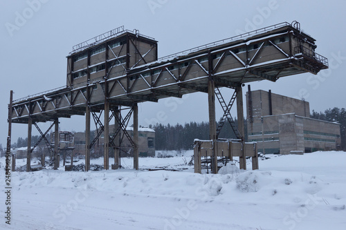 abandoned rock mining plant in winter under unclean snow