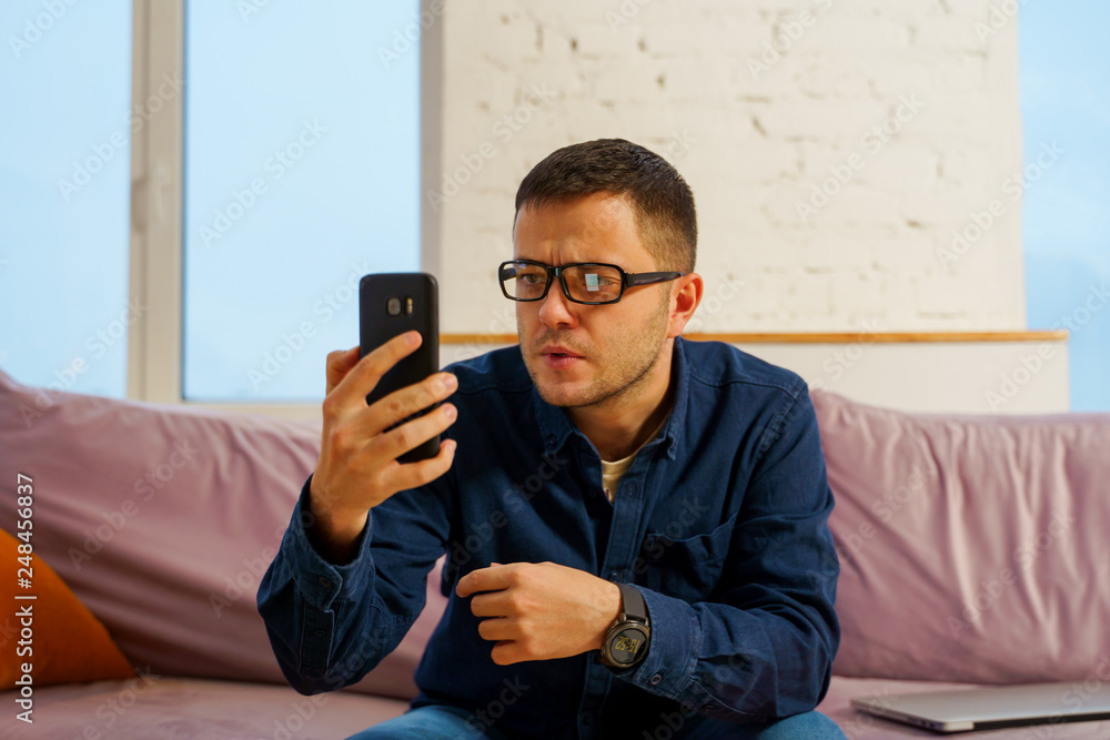 Man sit on the couch and using smartphone Man sit on the couch and using smartphone