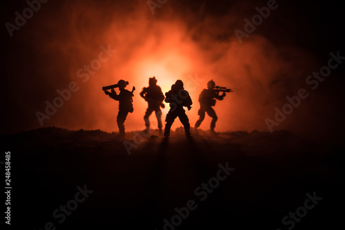 Military soldier silhouette with gun. War Concept. Military silhouettes fighting scene on war fog sky background, World War Soldier Silhouette Below Cloudy Skyline At night. © zef art