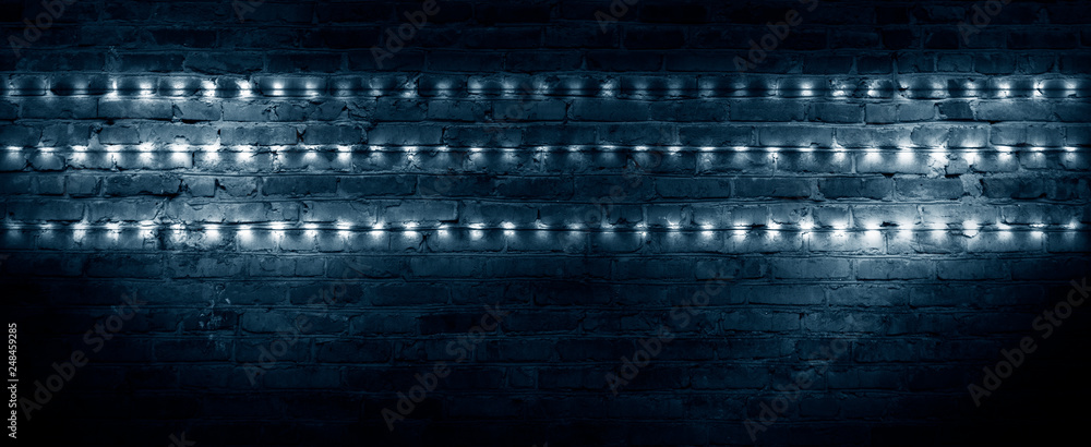 Old brick wall, dark room with brick wall, rays of searchlight light, illuminated night lights on an empty wall. Dark street, night city.