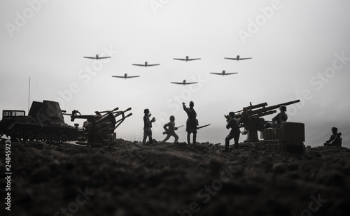 Fotografia An anti-aircraft cannon and Military silhouettes fighting scene on war fog sky background
