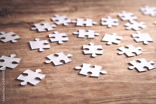 Pieces of the jigsaw puzzles on wooden background.