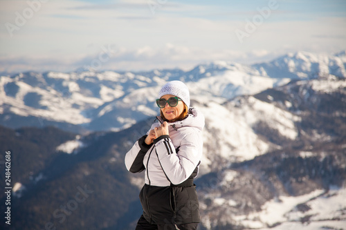 Winter sporty adult woman portrait with snowy mountains on background in Bakuriani, Georgia