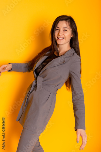 beautiful and sexy woman wearing a gray suit with a stylish women's jackets and pants. Conception of business woman, student, young business lady.