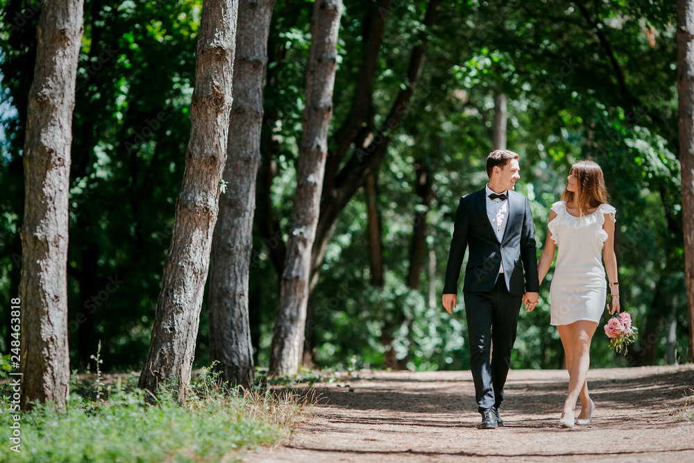 Happy couple walks in the park enjoying tender moments. Happy couple walks in the park enjoying tender moments.
