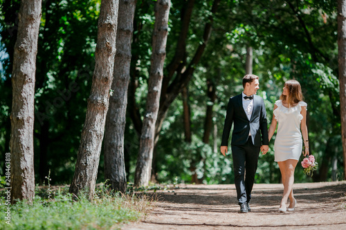 Happy couple walks in the park enjoying tender moments. © CRISTINA