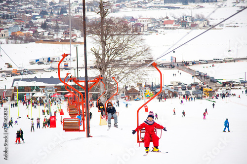 Wallpaper Mural Little girl in red winter overall using chairlift in Bakuriani ski resort, Georgia Torontodigital.ca
