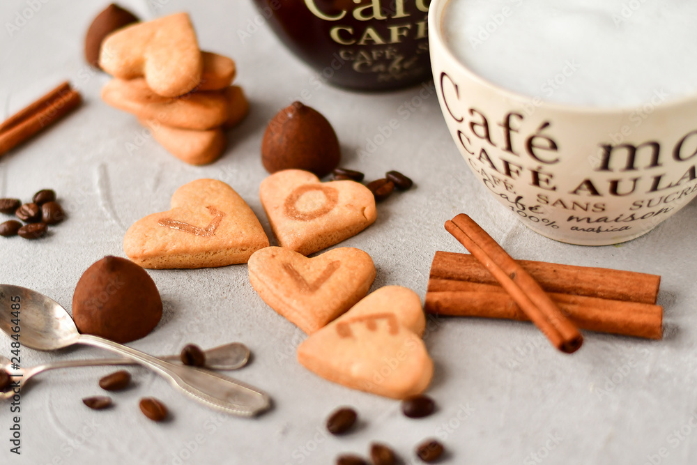 two cups of coffee and cookies in the shape of hearts, on the cookie letters LOVE. the concept of a gift for Valentine's day on February 14. selective focus two cups of coffee and cookies in the shape of hearts, on the cookie letters LOVE. the concept of a gift for Valentine's day on February 14. selective focus
