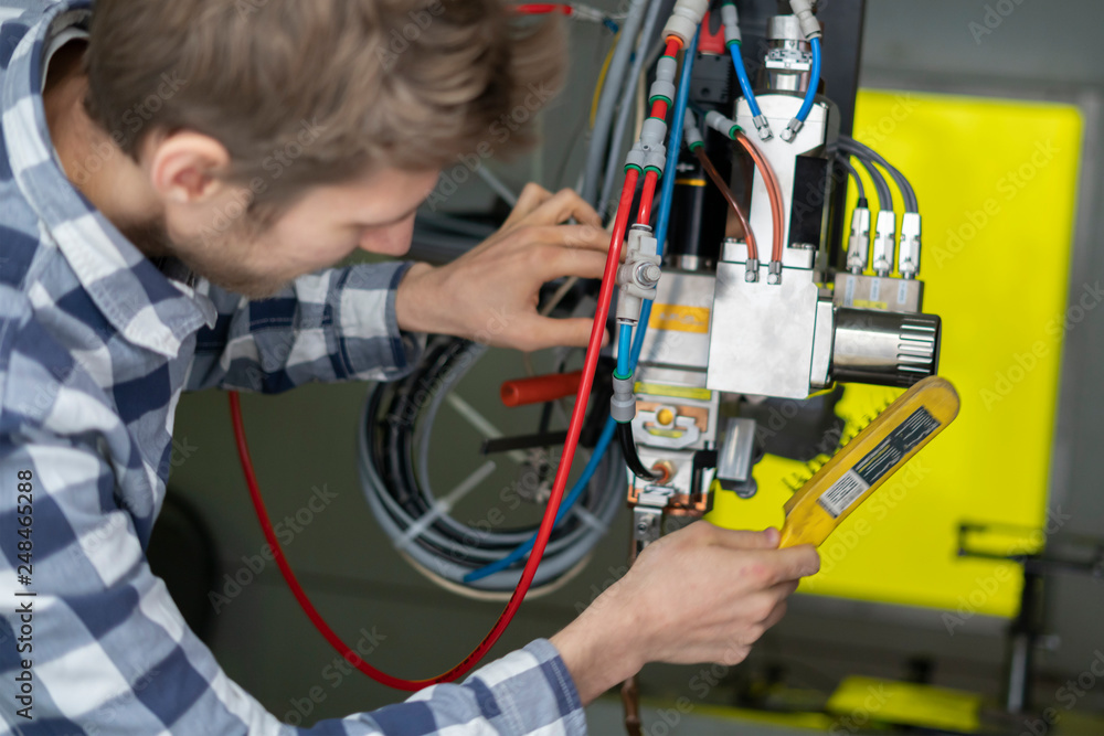 worker adjust industrial welding machine b worker adjust industrial welding machine b