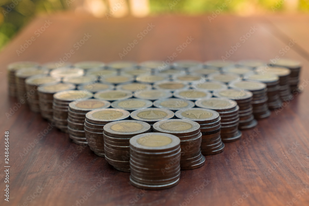 Thai Baht lots coin Arranged in triangle shape on with blurred background Thai Baht lots coin Arranged in triangle shape on with blurred background