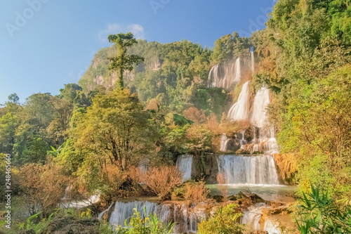 Thi Lo Su Waterfall  Umphang   beautiful silky water flowing from top of green mountain around with green forest and blue sky background  the largest waterfall in Thailand  Umphang  Tak  Thailand.