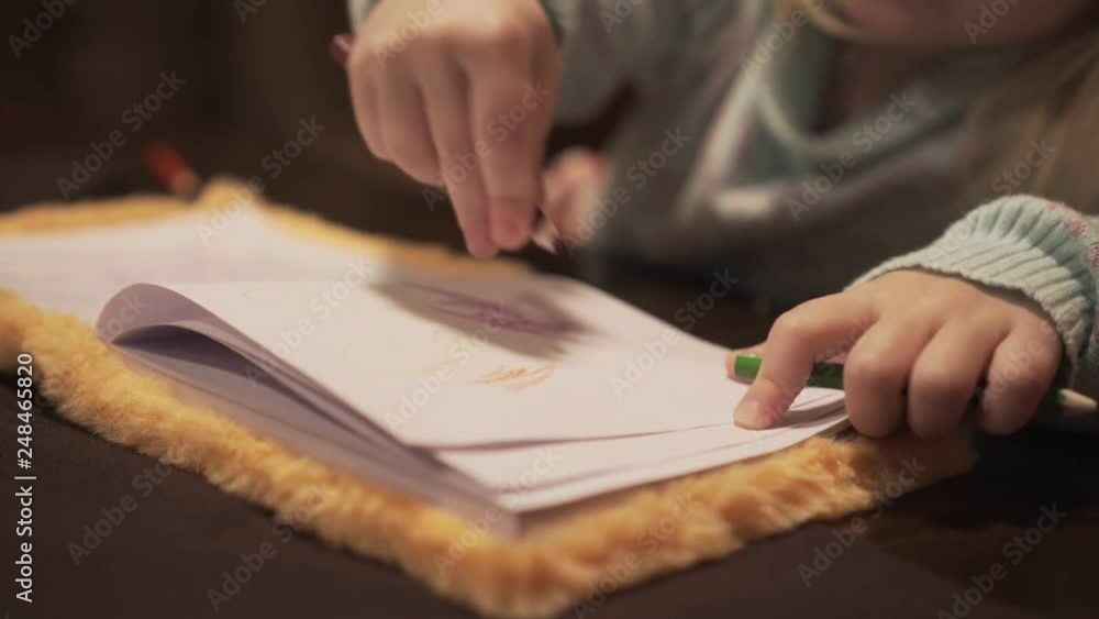 A little child girl draws with a pencil. A little child girl draws with a pencil.
