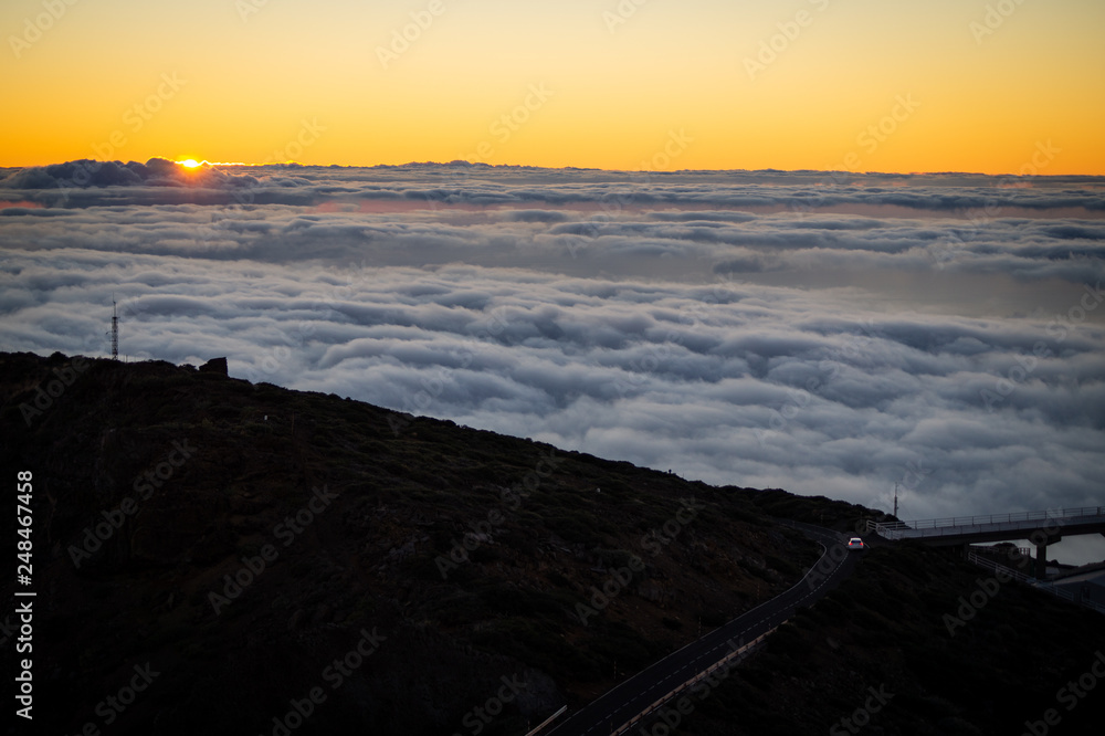 Obraz premium Car driving down the sunset in the mountains