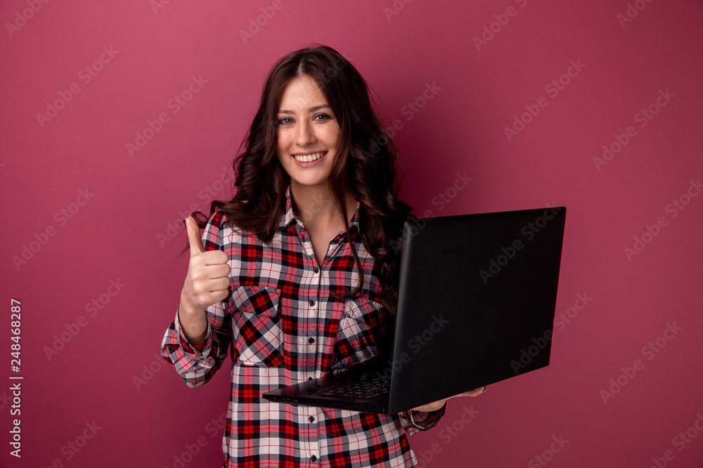 Portrait of an excited younggirl holding laptop computer and celebrating success isolated over gray background Portrait of an excited younggirl holding laptop computer and celebrating success isolated over gray background