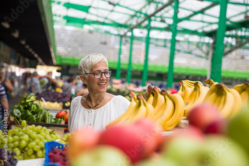 Portrait of senior woman buys bananas at the market © BGStock72
