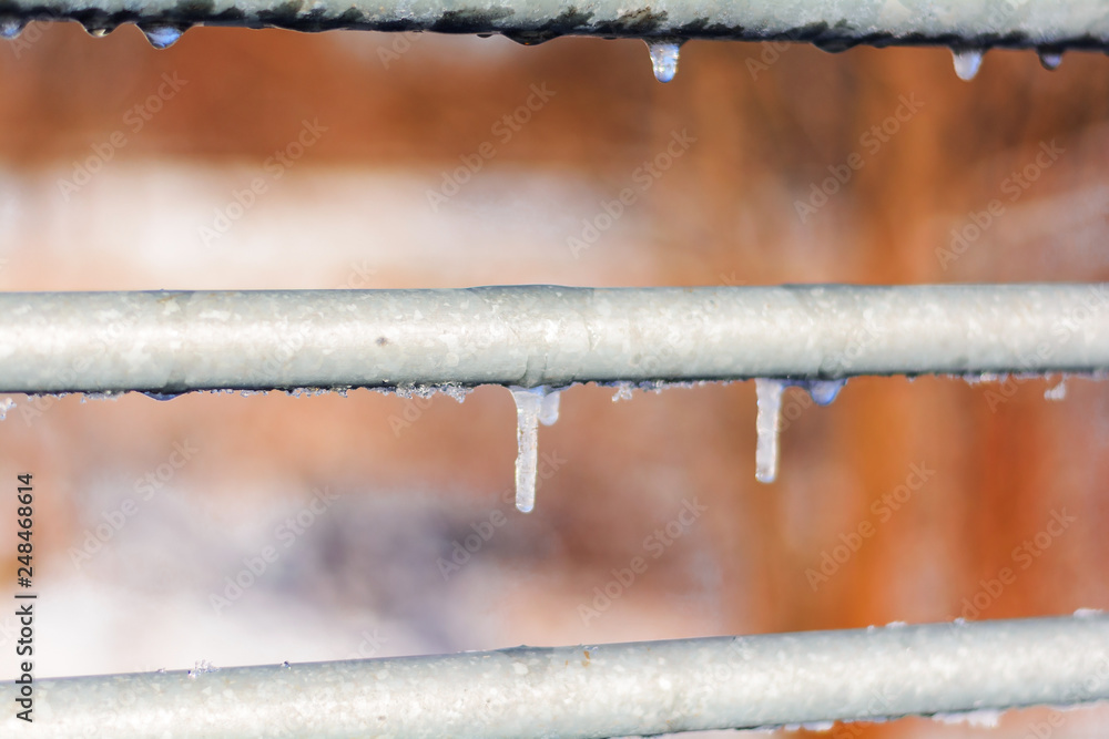 Small ice icicles on the metal railing of the bridge Small ice icicles on the metal railing of the bridge