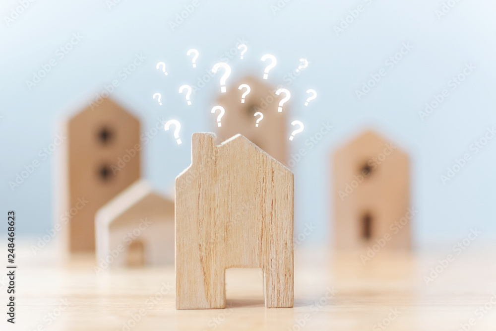 Real estate developer and managing property investment concept. Selective focus wooden houses with question mark on table - obrazy, fototapety, plakaty 