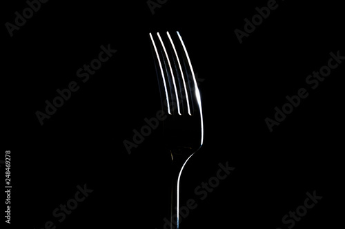 Fork on a black background with light from the side