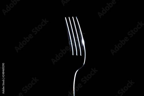 Fork on a black background with light from the side