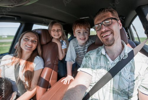 cheerful family with two children goes to the car