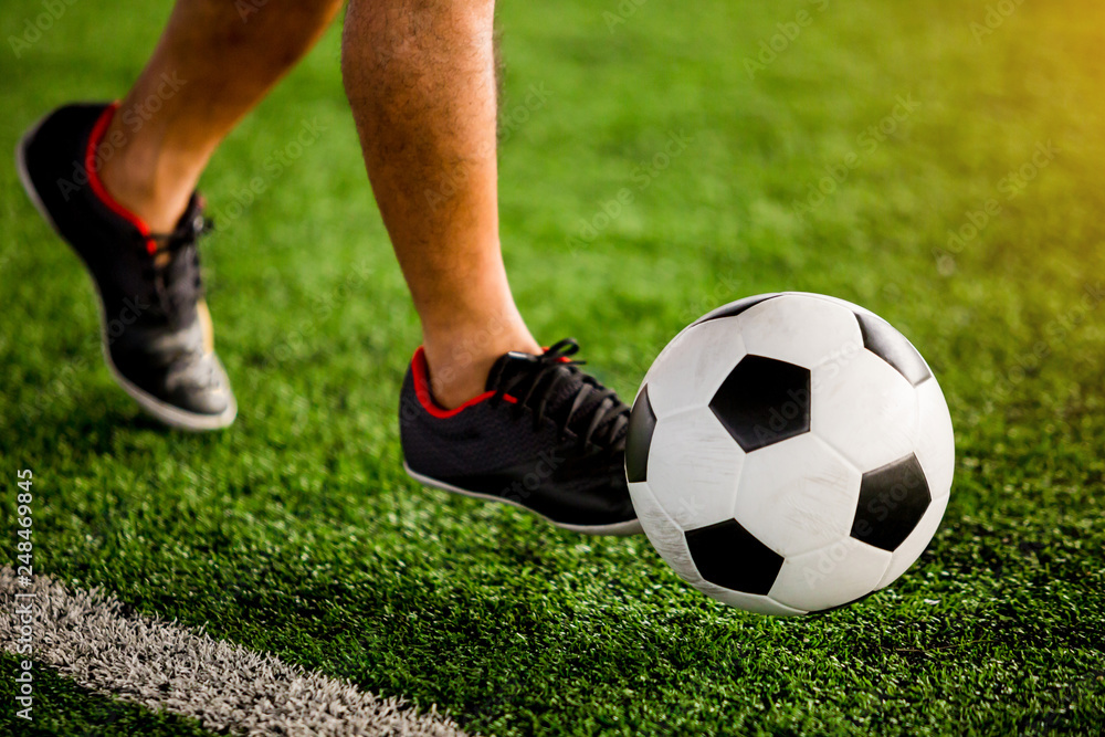 Soccer player speed run to shoot ball to goal on artificial turf