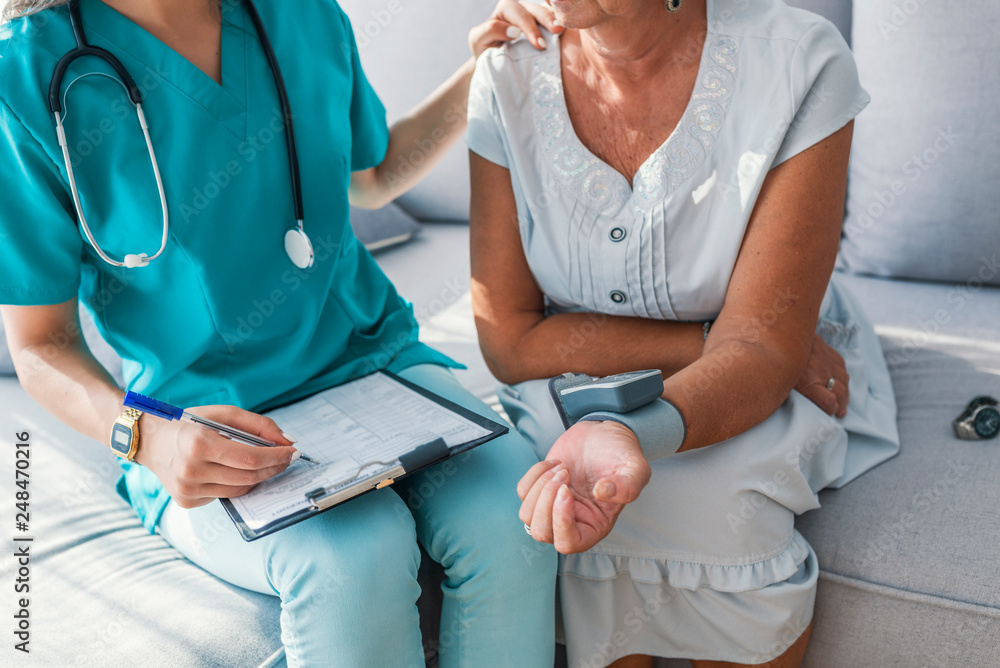 Φωτογραφία Female doctor measuring blood pressure of senior woman