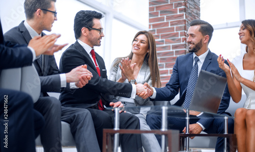 colleagues applaud business partners at a business meeting