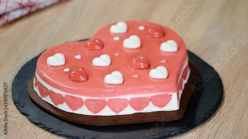 Confectioner decorating heart-shaped mousse cake. Cake for Valentines day. photo