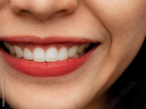 Closeup shot of human Asian Chinese Thai woman female makeup face. Woman with red lips lipstick and healthy dental white great perfect teeth. Smiling, Dental dentist clinic concept.
