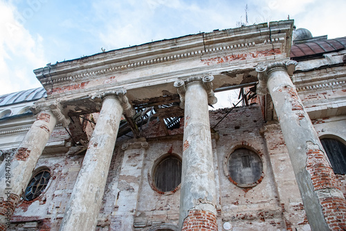 Canvas-taulu columns with collapsing ceiling next to the dilapidated building