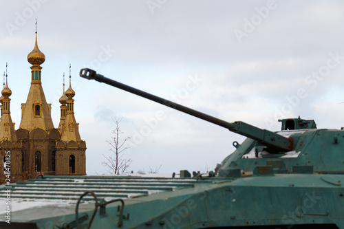 Bild auf Leinwand Infantry fighting vehicle as a monument on the background of the church