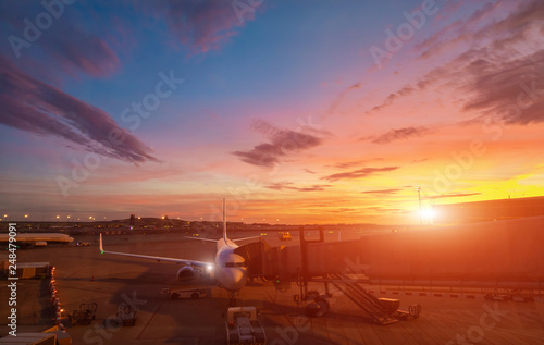 Airplane at the terminal gate ready for takeoff. International airport during colorful sunset - Concept Travel around the world