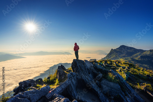 Wall Mural Traveler standing on the rock, Doi pha tang and morning fog in Chiang rai, Thailand