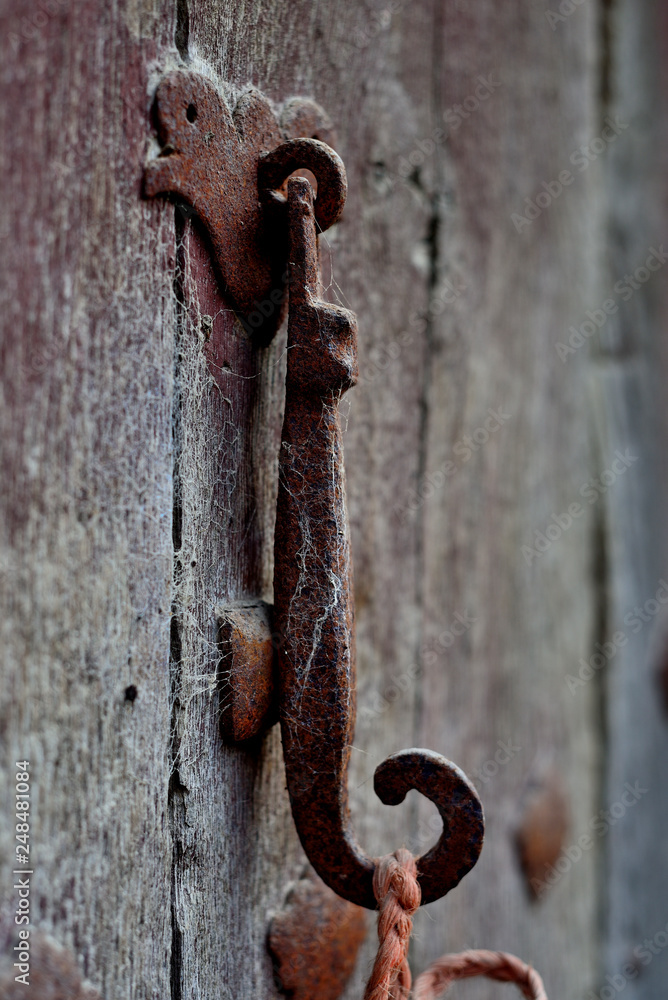 rusty knocker on an old wooden door in an abandoned house in the village of Monasterioguren (alava) Pais Vasco, Spain rusty knocker on an old wooden door in an abandoned house in the village of Monasterioguren (alava) Pais Vasco, Spain