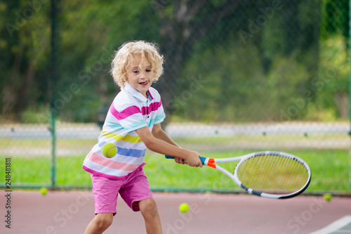 Child playing tennis on outdoor court