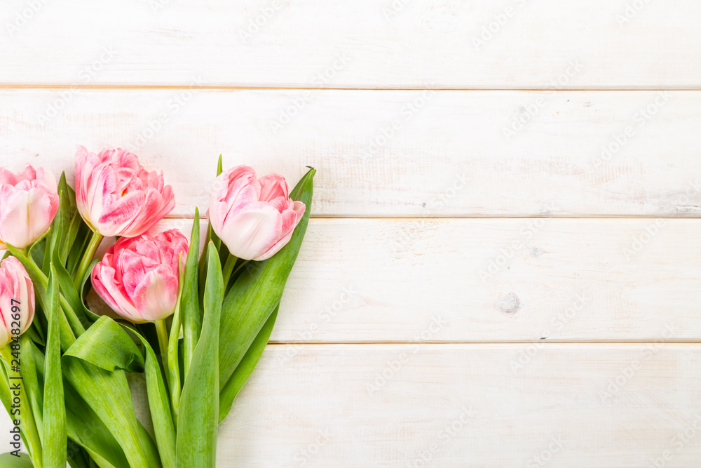 Mother's day concept - pink flowers on wood background, top view Mother's day concept - pink flowers on wood background, top view