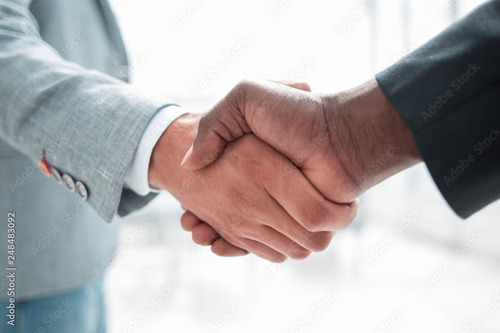 Business handshake in lofty office Business handshake in lofty office